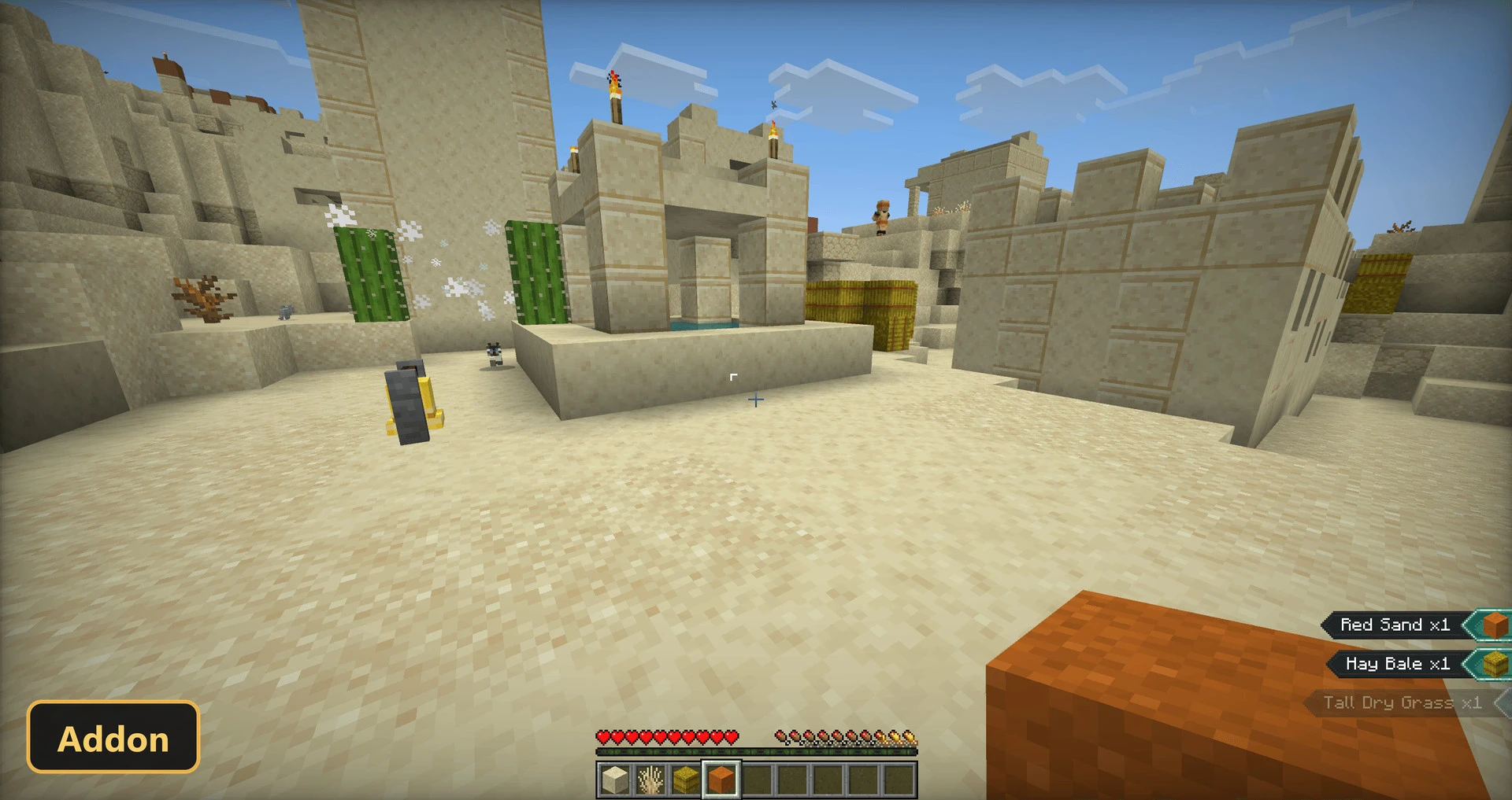 desert village, sand, sandstone structures, cacti, hay bales, daytime