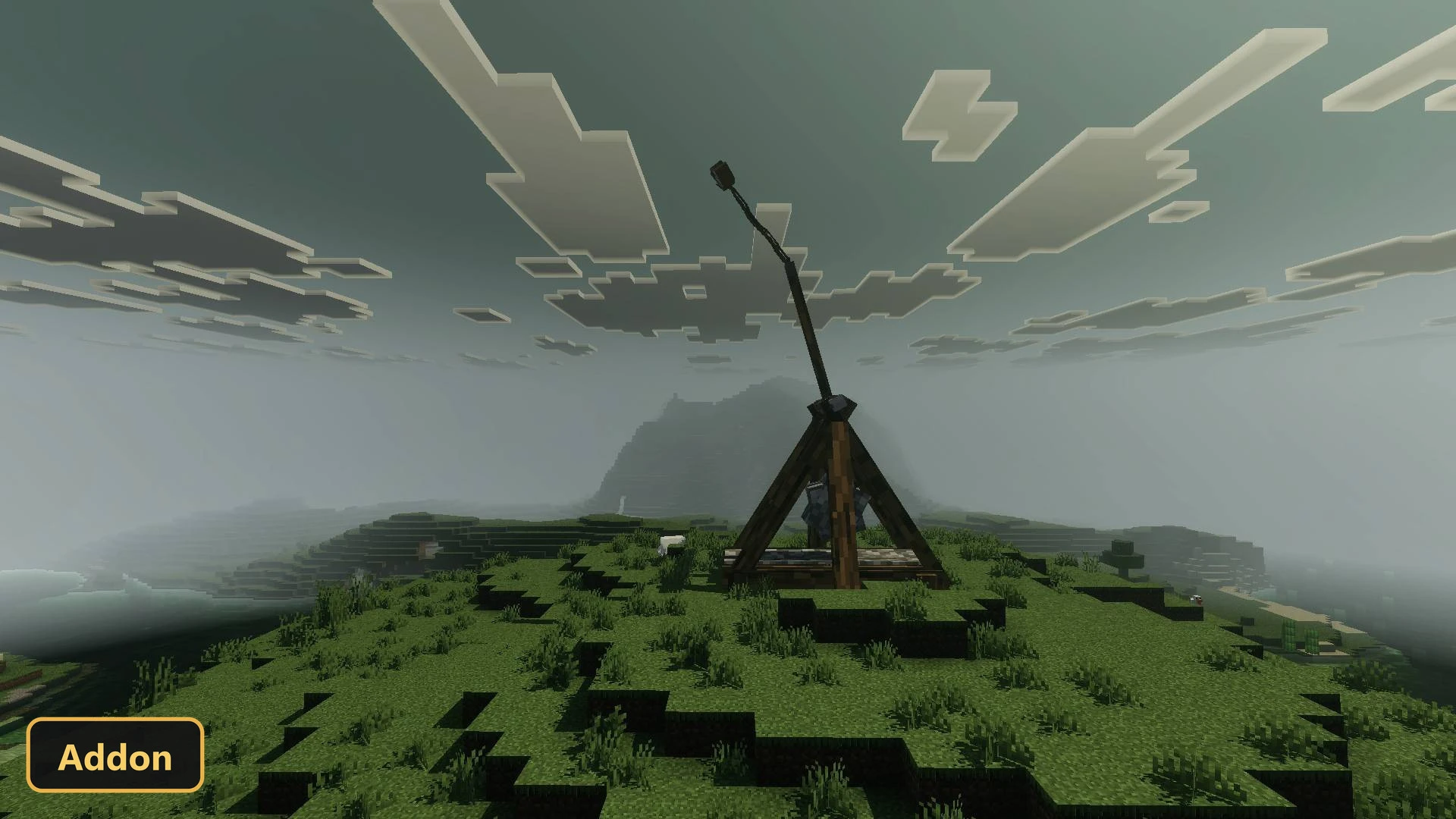 single trebuchet on a grassy hill under a cloudy, misty sky